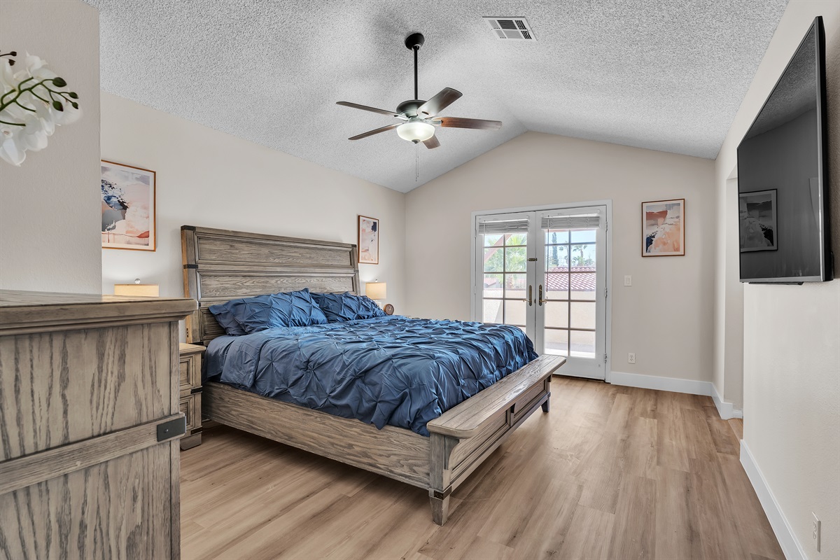 Bedroom 4 with king bed, 60 inch smart tv, walk in closet with table/chair, ensuite bathroom, and dresser