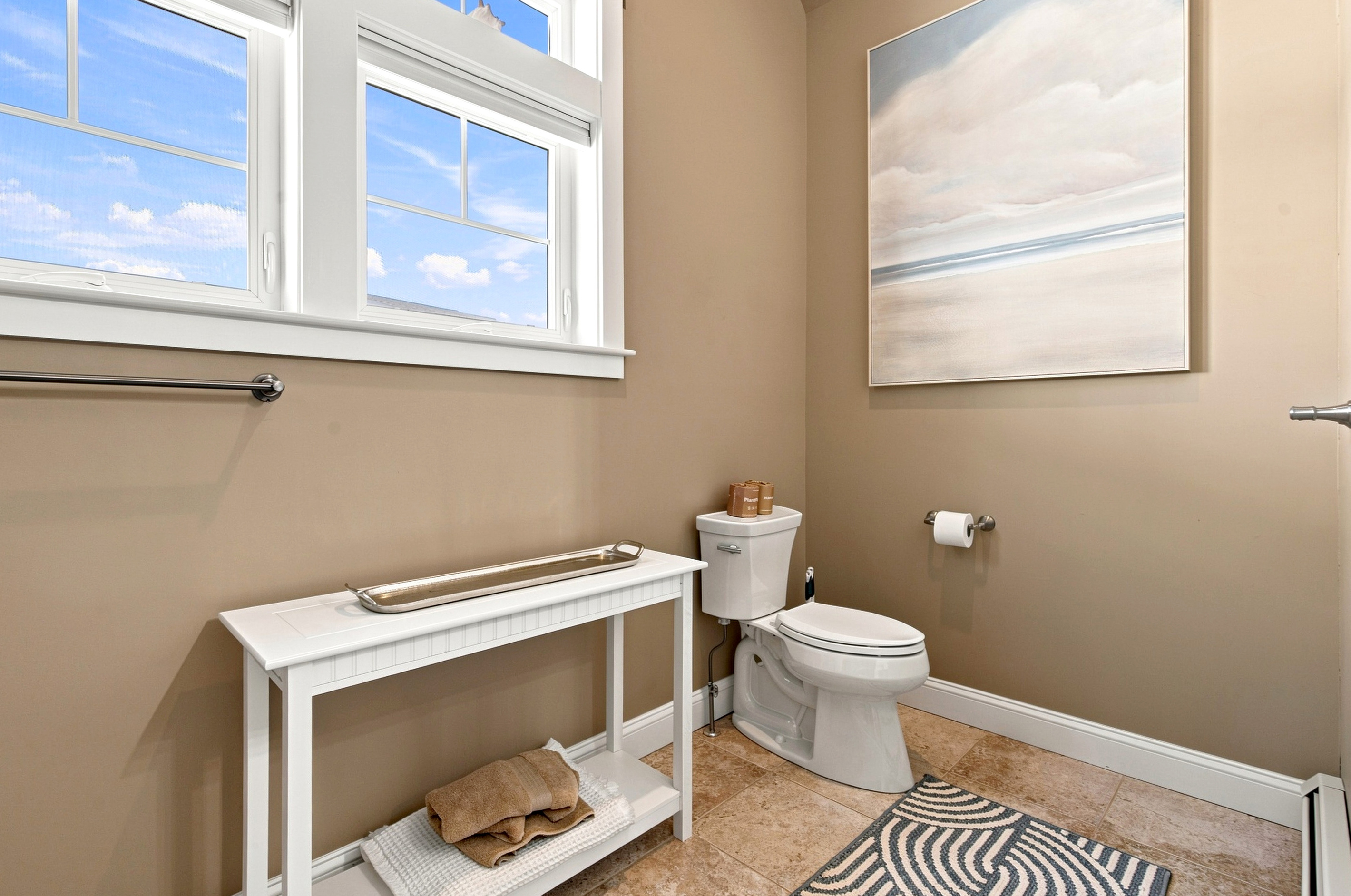 A bright and convenient bathroom with natural light and thoughtful space for everyday essentials.