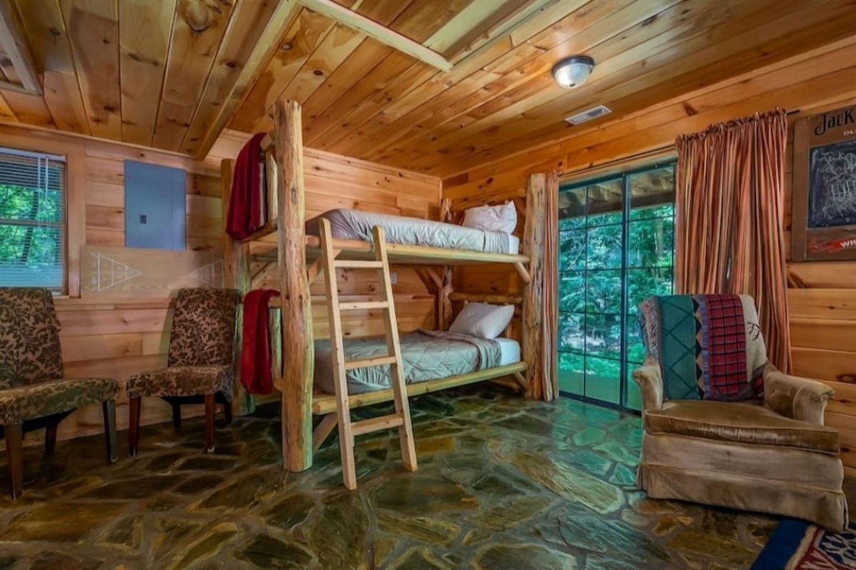 bedroom three with 2 sets of log bunks, full bathroom, game room and French doors to lower deck, Hot Tub and private back yard.