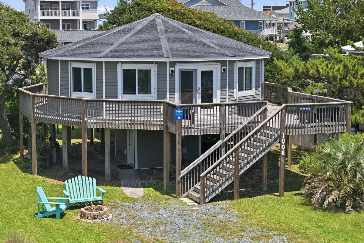 Bird's-eye view highlighting the home's unique design, wraparound deck, generous outdoor space, and ample parking