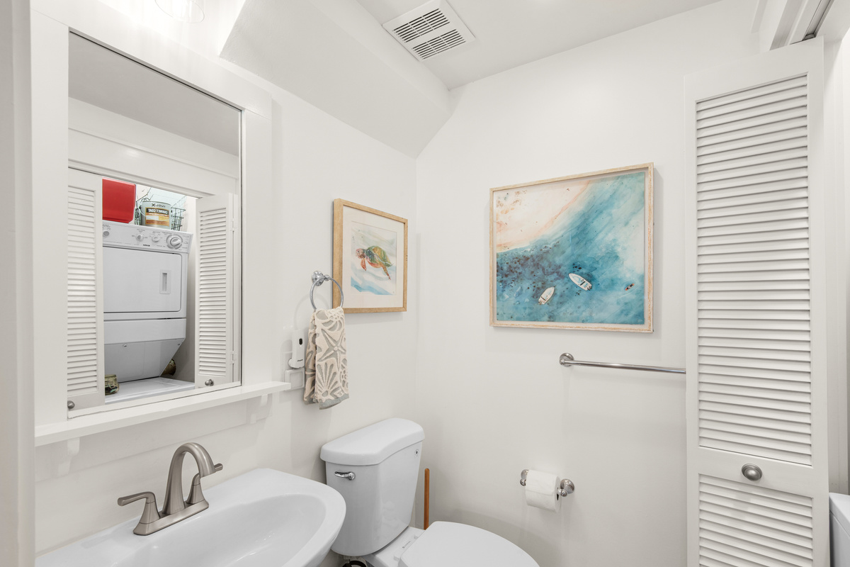 Seagrove Bungalow 103 half bathroom with a toilet, sink and adjacent laundry closet.