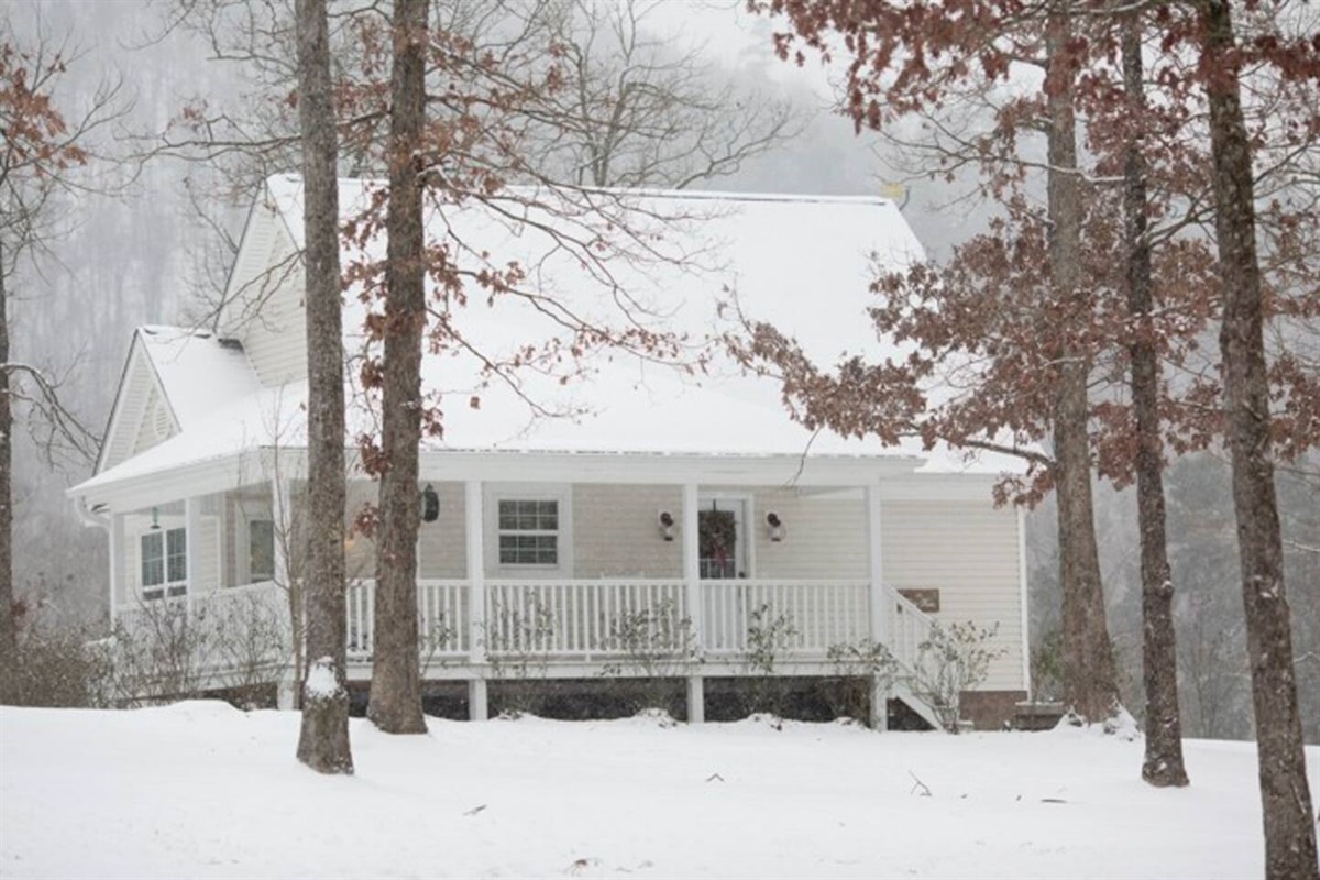 Christmas cottage on snowy day.  Perfect romantic getaway at cabin rental in Arkansas