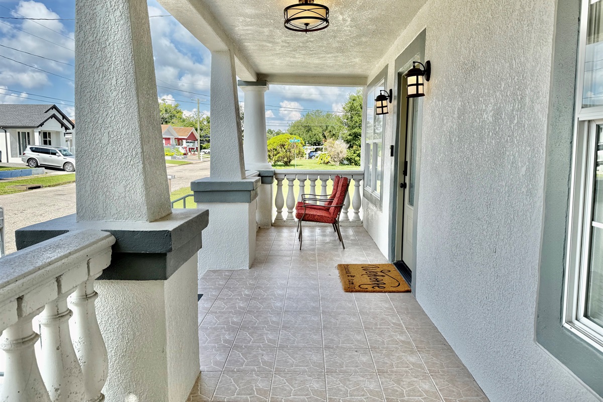 Start your mornings or wind down your evenings on this spacious front porch—complete with cozy cushioned chairs and peaceful palm views.