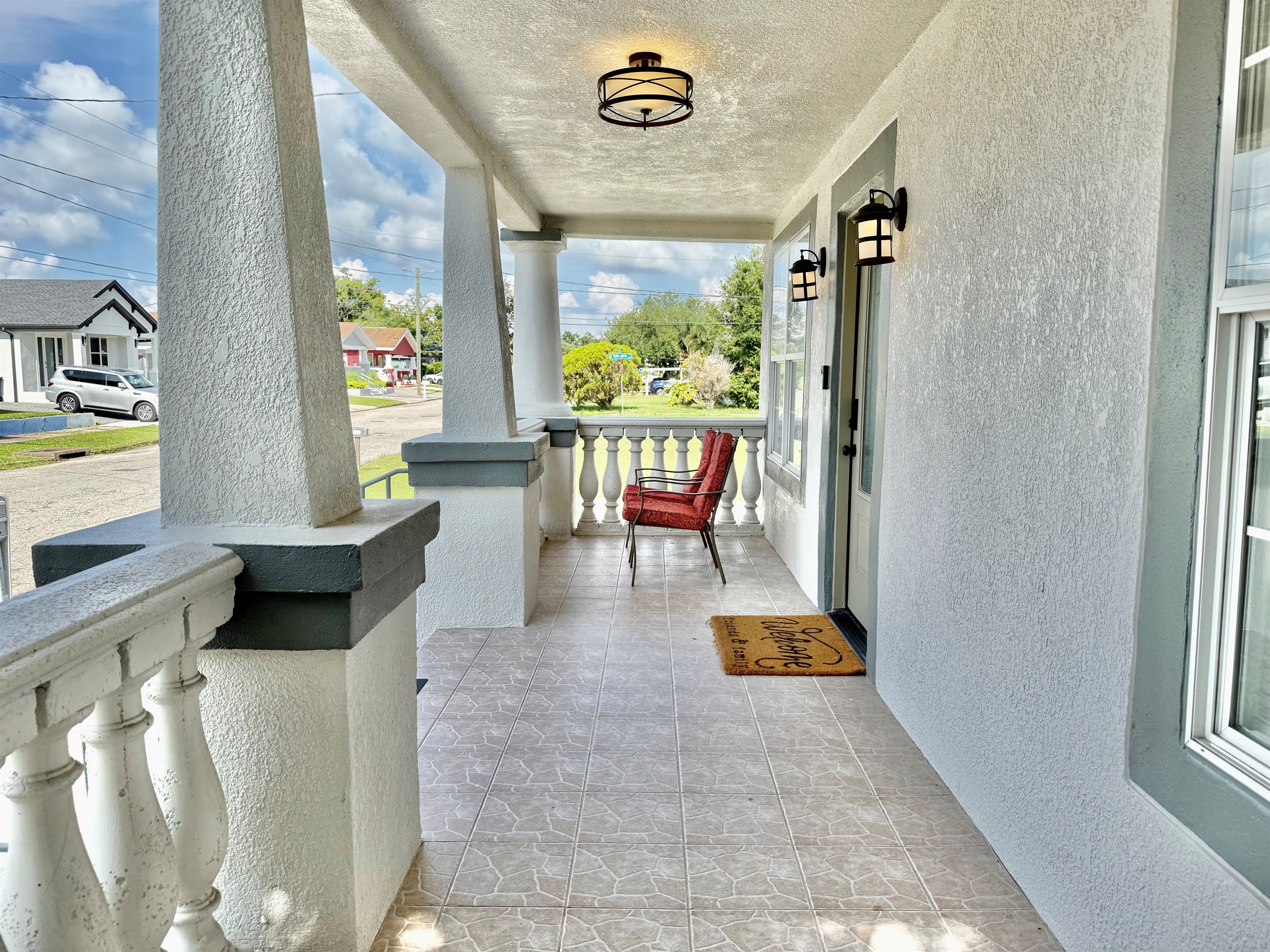 Start your mornings or wind down your evenings on this spacious front porch—complete with cozy cushioned chairs and peaceful palm views.