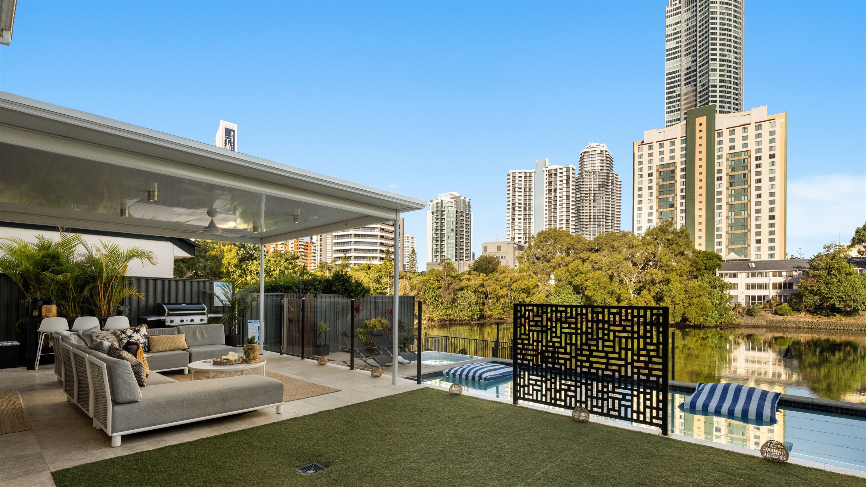 Private waterfront setting with open lawn space and seamless indoor–outdoor flow.