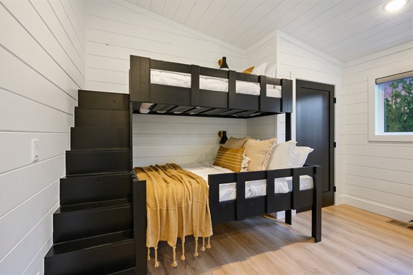 Custom bunk beds with built-in stairs make this space perfect for kids and teens.