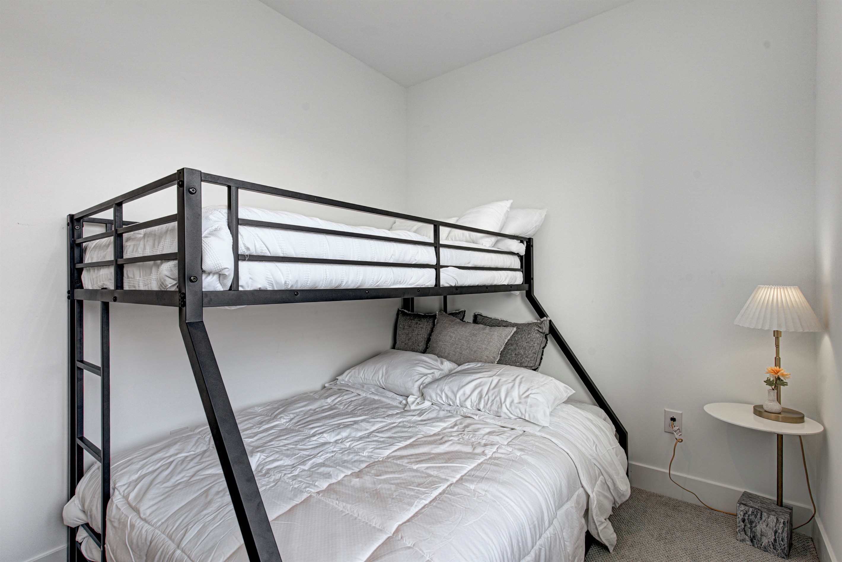 Relax in the serene bedroom featuring a comfortable king-size bed, soft linens, and cozy pillows. Includes nightstands, lamps, walk-in closet, and full-length mirror for added comfort.