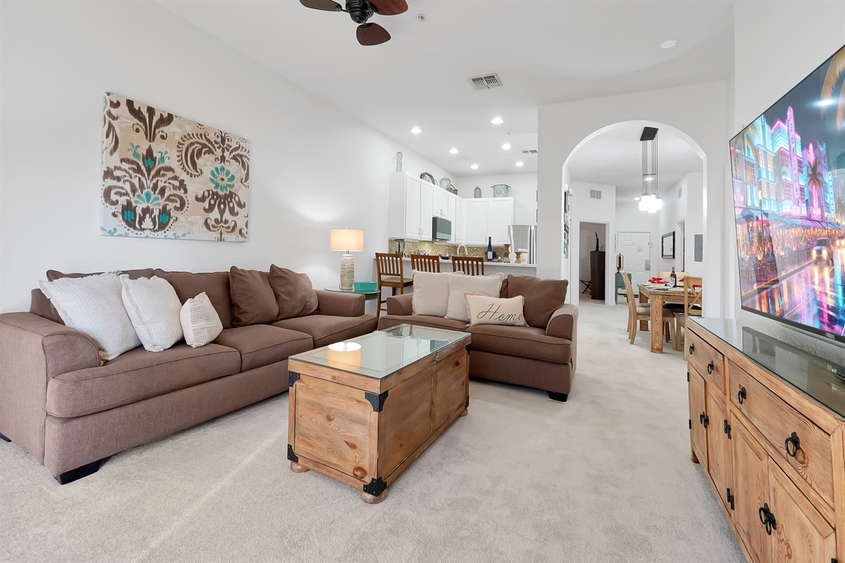 Open space living room with kitchen in background