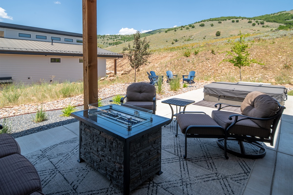 Covered patio with cushioned seating and fire table for year-round enjoyment