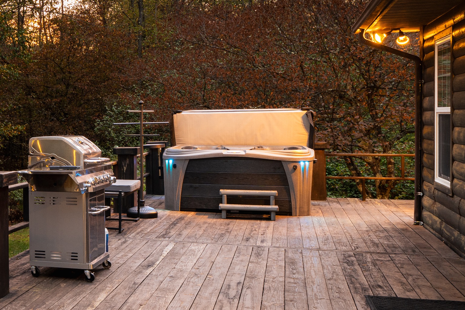 Private hot tub nestled in the trees on the back deck — unwind under the stars after a day exploring the 75+ acres at Runway Retreat