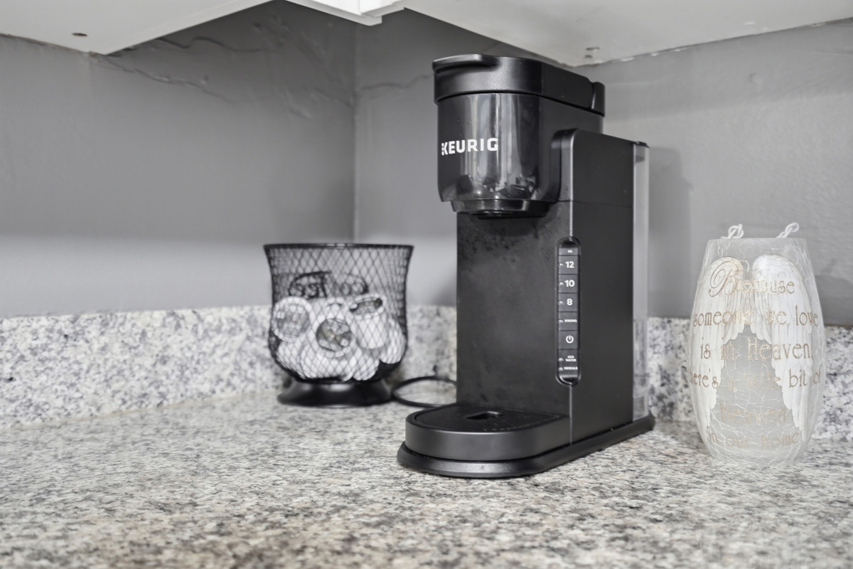 The fully equipped kitchen features stone countertops, solid wood cabinets, and modern appliances, including a refrigerator, range/oven, microwave, dishwasher, and garbage disposal. Everything you need to prepare meals.