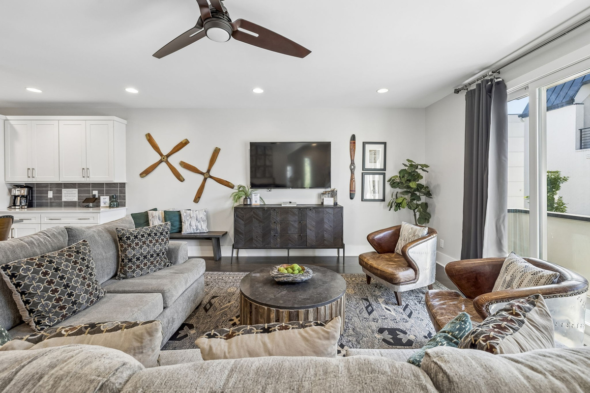Rich leather club chairs paired with a rustic wood coffee table create an inviting nook - Decorative tray with sparkling water & greenery adds a polished, welcoming touch - Layered textures & industrial modern vibes make this a perfect spot to unwind
