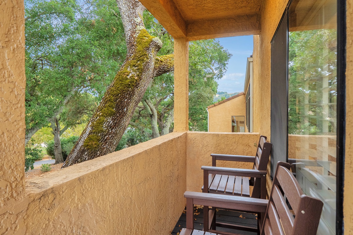 Discover your own cozy, shaded corner on this private balcony. Perfect for enjoying a quiet book or an intimate morning coffee, surrounded by the natural beauty and mature trees.