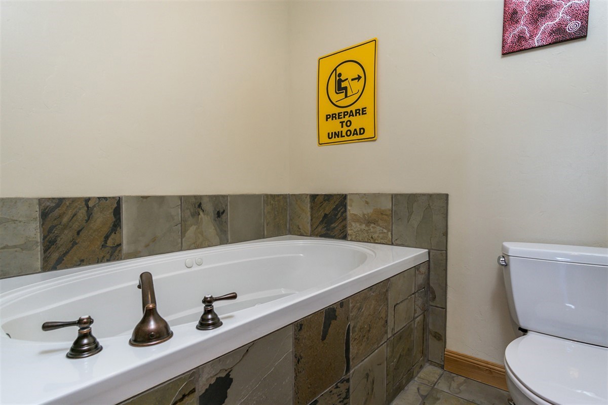 Unwind in a spa-inspired bathroom featuring a deep soaking tub and elegant finishes—your private sanctuary after a day of mountain adventures.