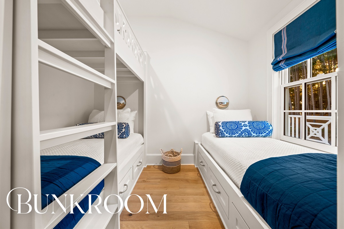 Bunkroom featuring built-in beds and coastal style.