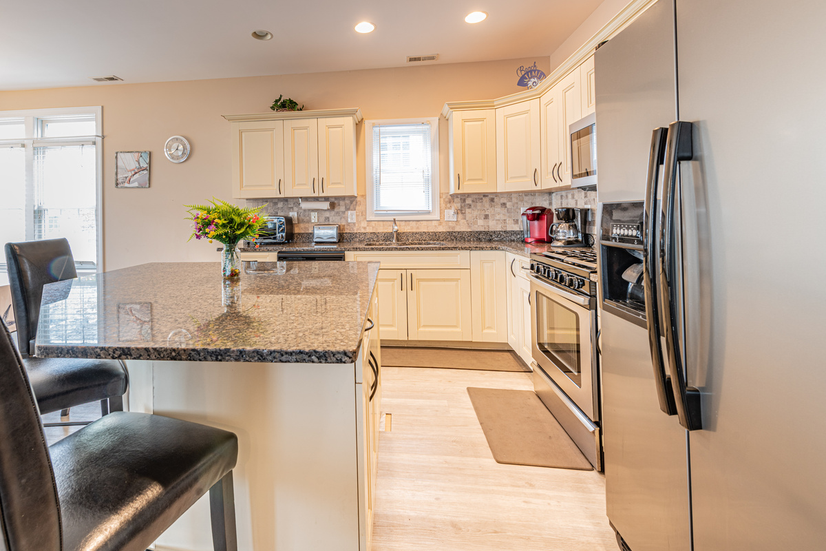 Kitchen Interior View Featuring Island, Granite Countertops, and Refrigerator