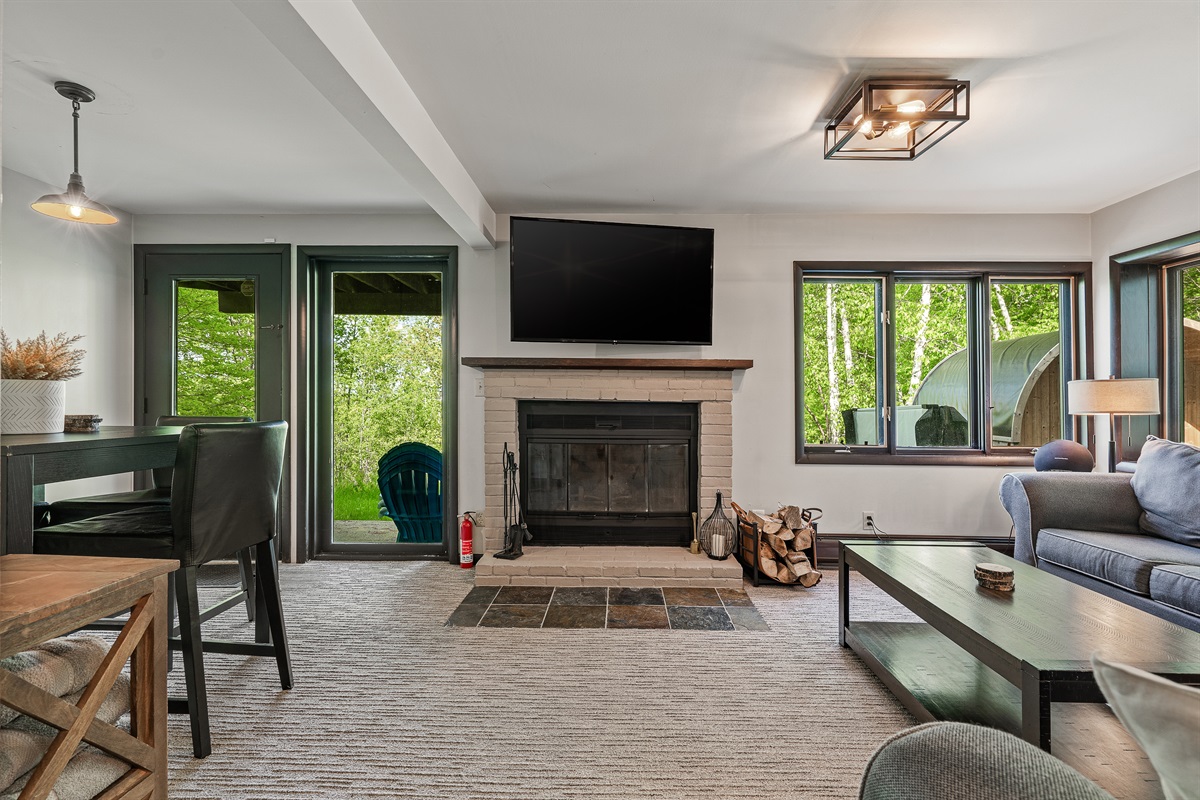 Unwind in the lower-level living room, equipped with a TV and cozy seating for movie nights or game days.