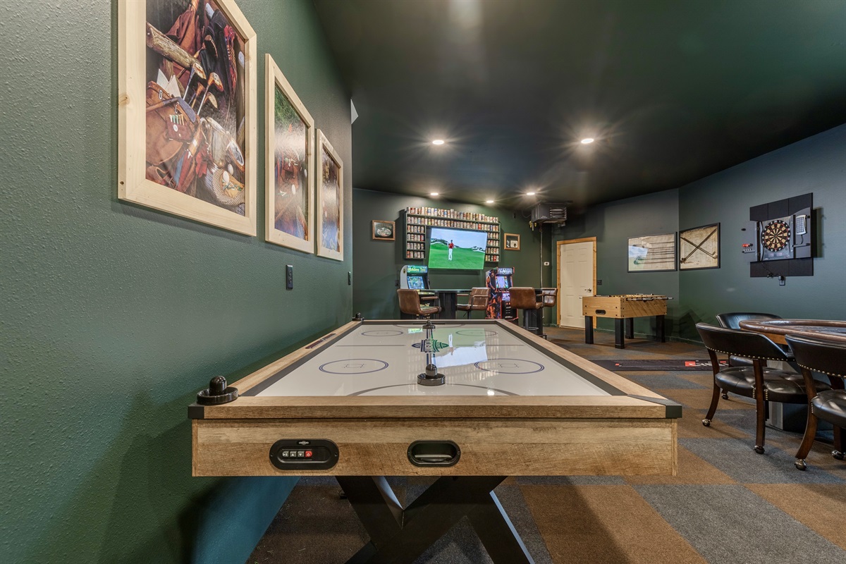 Check out this garage made game room.  Equipped with air hockey, 6-person poker table, putting green, arcade games, dartboard, foose ball and two smart TVs.