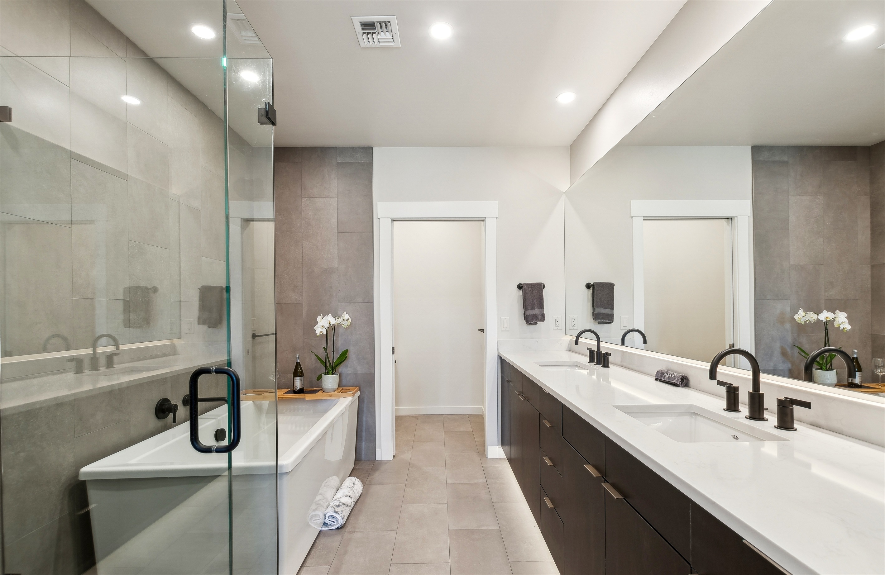 The master suite bathroom with double vanity, giant soaker tub, private toilet, and a tile shower.
