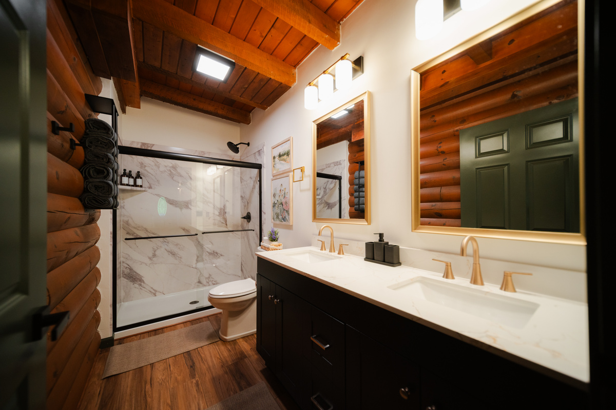 A beautifully designed bathroom where modern finishes meet warm, rustic cabin charm.