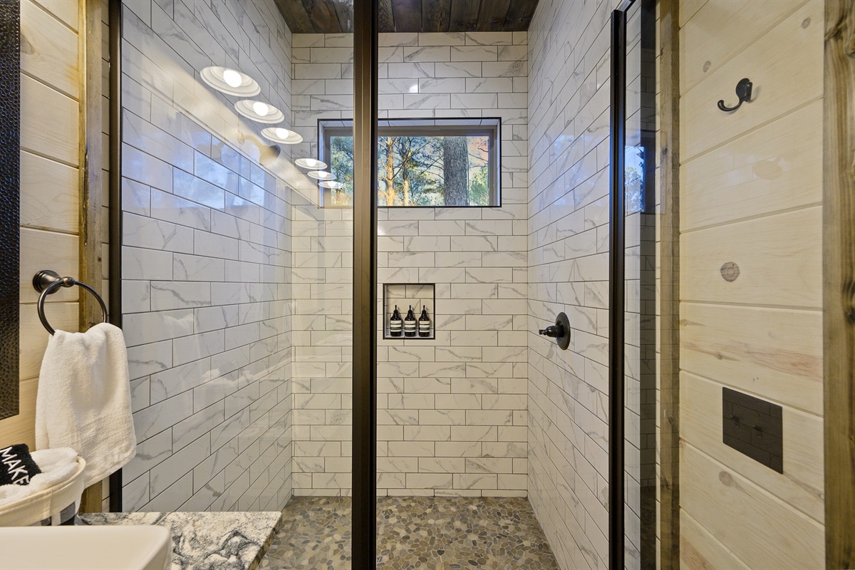 The walk-in shower feels spa fresh with crisp tile and built-in niches. Step under warm water and shake off the day.