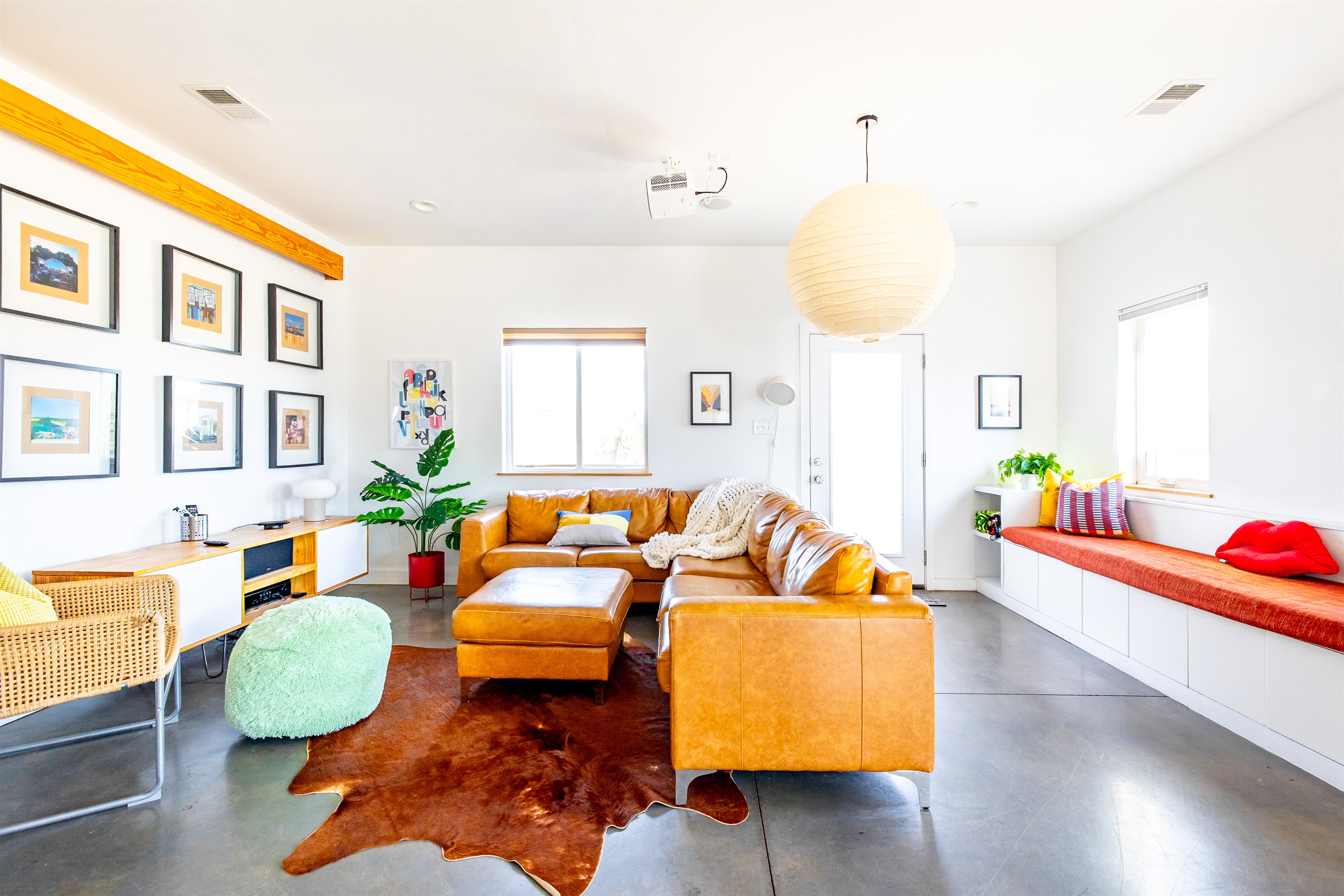 Living room with massive carmel leather sectional, 15' long window seat, Noguchi chandelier, and PROJECTOR! Ceiling speakers and Yamaha system make this the ultimate media experience. Not to mention the clean modern architecture!
