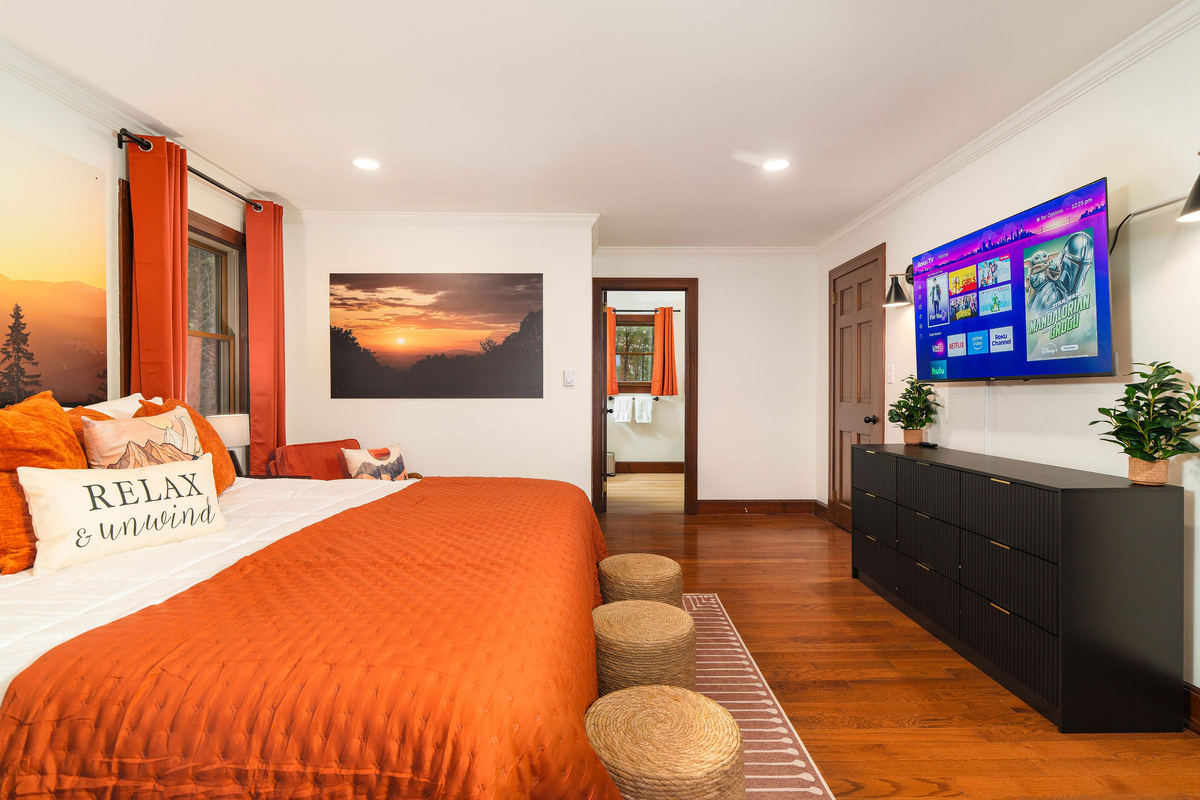 🛏 The Sunset Room primary suite — king bed, large HDTV, and a private ensuite bath.