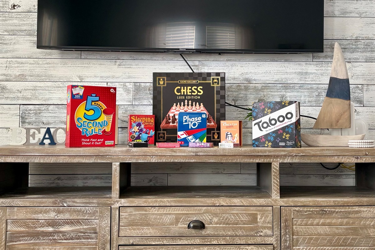 Entertainment console with TV and a selection of board games for guest enjoyment.