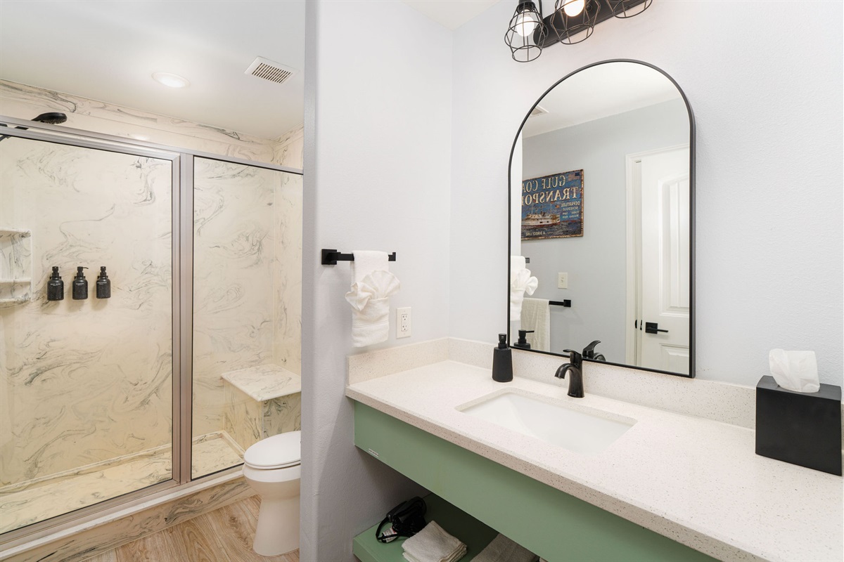 Titanic ensuite bath — marble-look shower, green vanity. Private to the main-floor King suite.