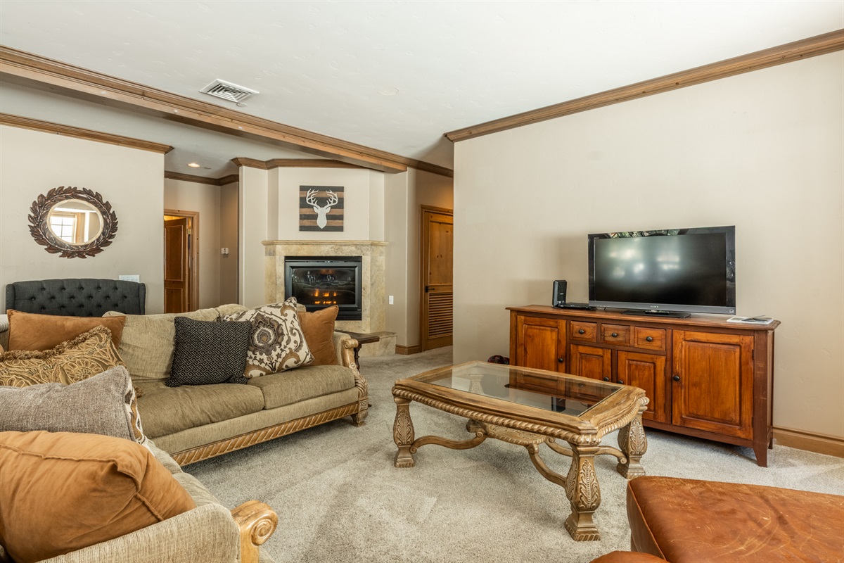 A calm, inviting Noble Nest living space anchored by a gas fireplace and comfortable seating—ideal for unwinding after a day on the mountain.