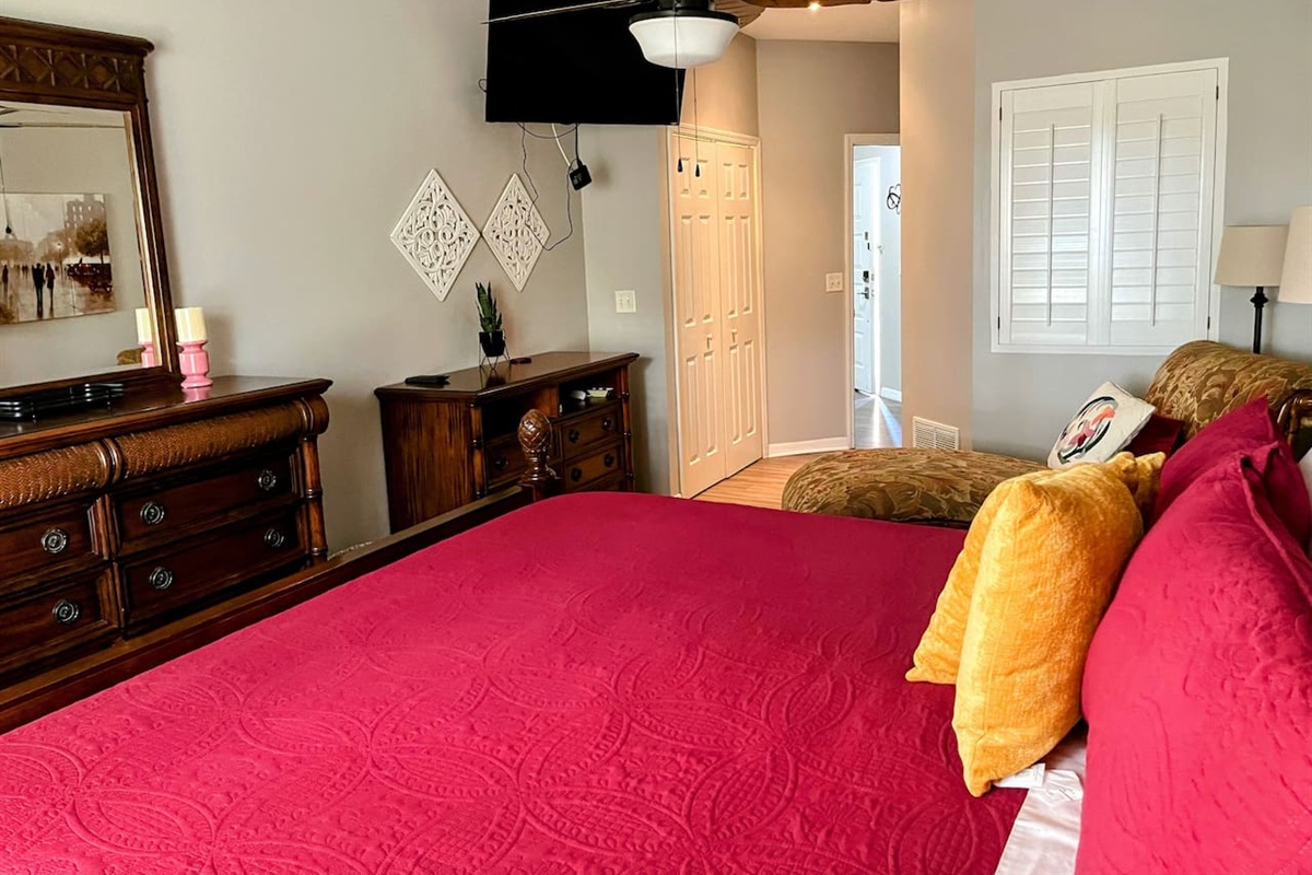 Comfortable bedroom with a large bed, dresser storage, closet access, and a relaxing layout.