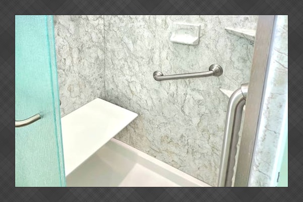 walkin shower with sitting ledge and handle bars. shampoo and soap