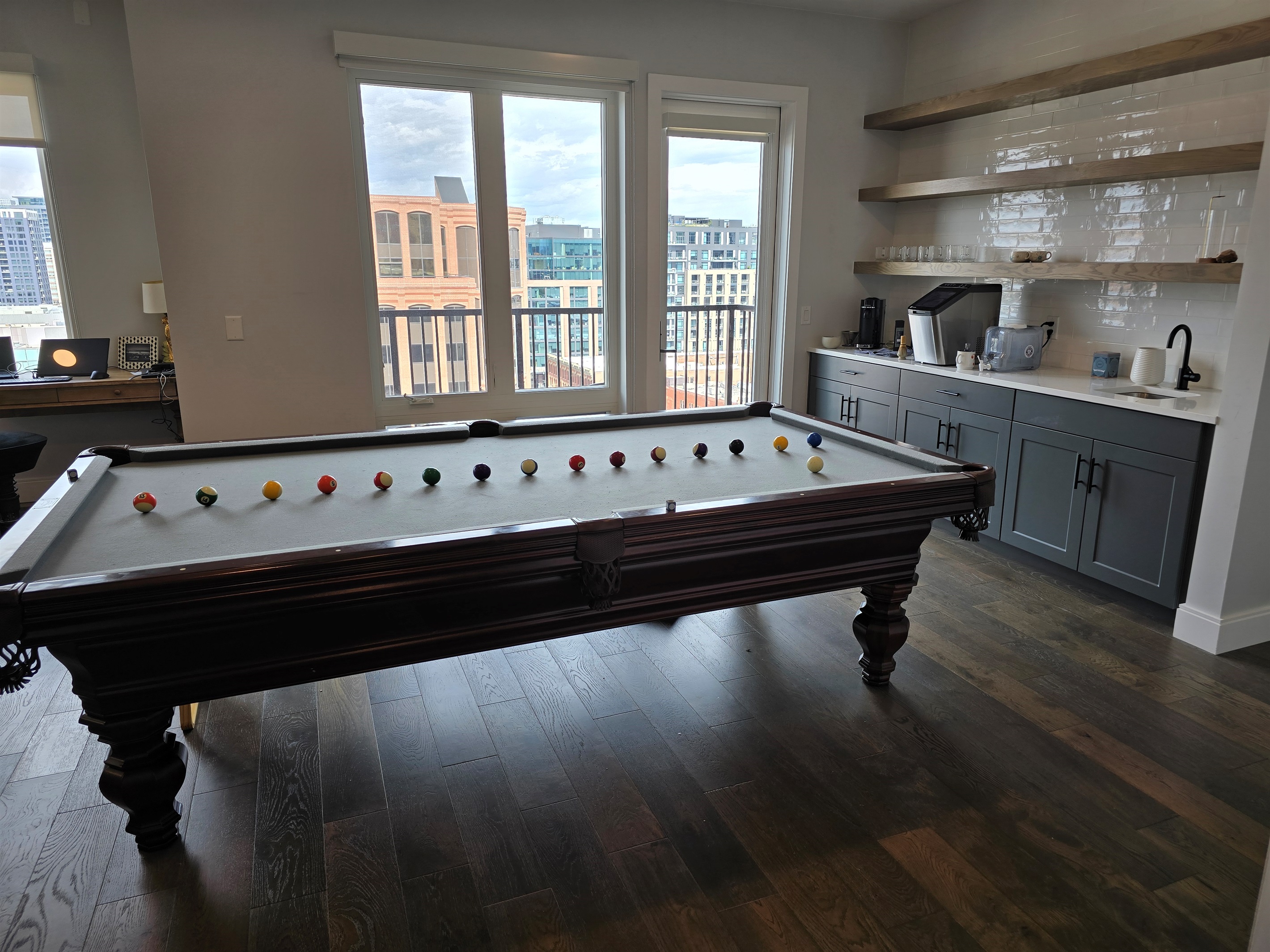 Amazing downtown view while playing pool and bar/sink area close by.