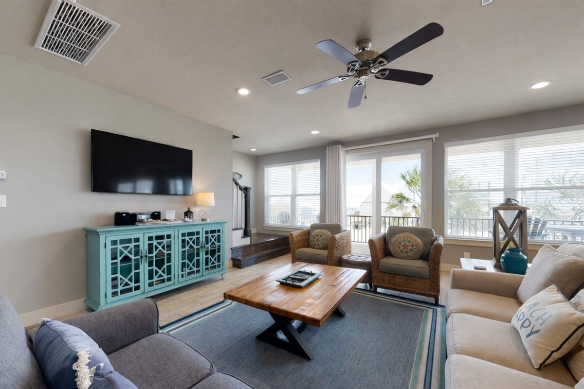 Living room area with plenty of seating and wall mounted Smart TV. Guests must log in to their own streaming services