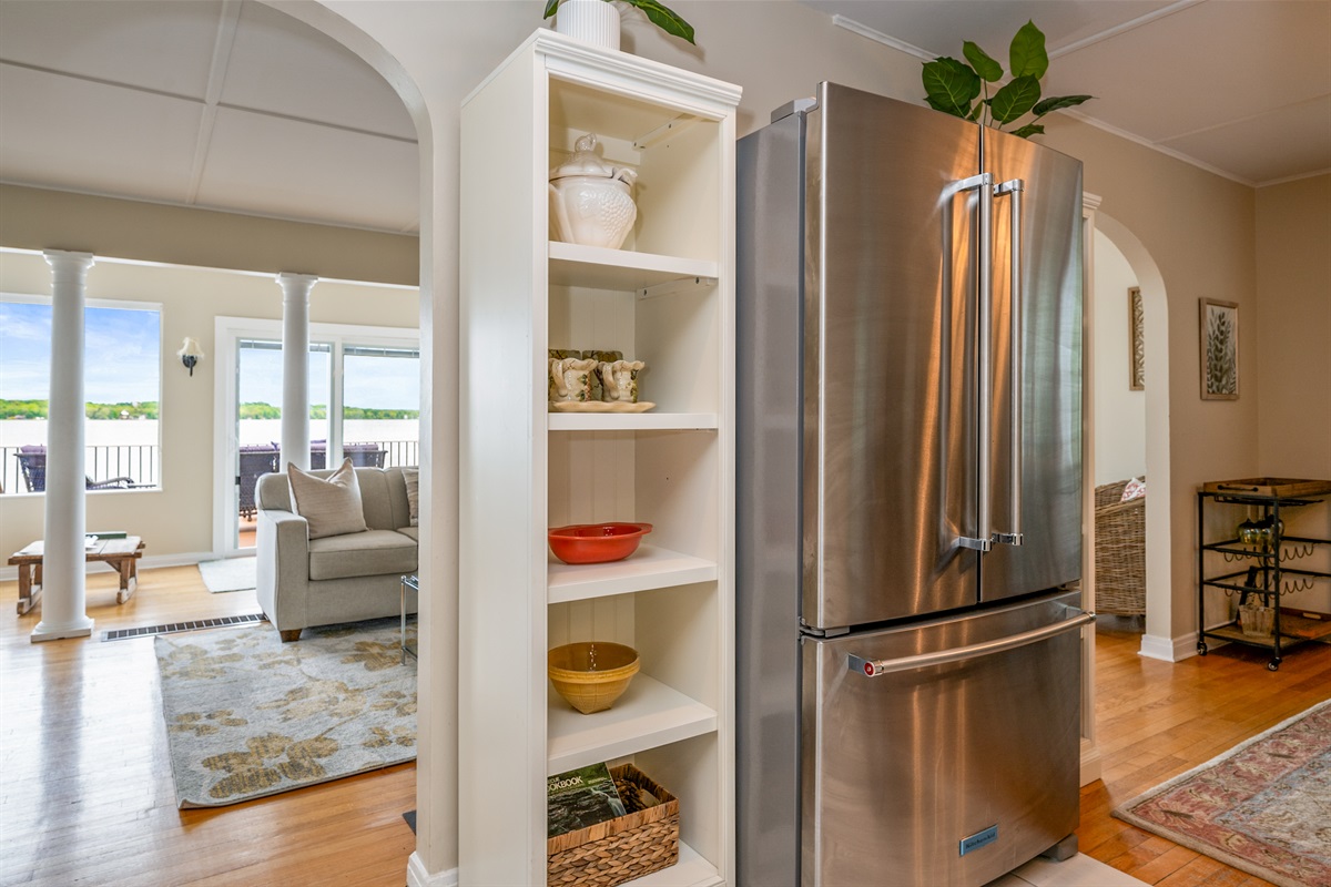 Seamlessly connected kitchen and living spaces with stainless steel appliances and charming open shelving 🏡🥣🛋️