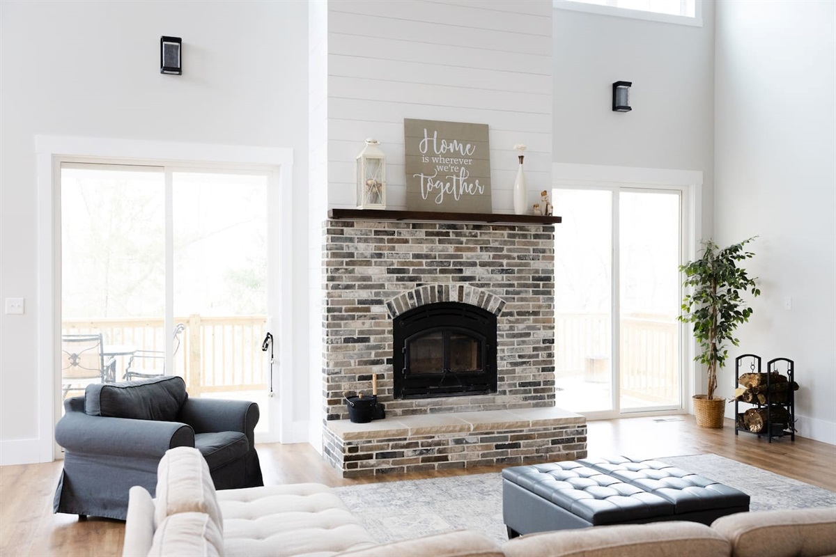 Spacious living room is open to the kitchen and second floor balcony. Master bedroom and library are just off the living room. Two stories of deck space are accessible out the doors by the fireplace opposite the couch. 85" TV.