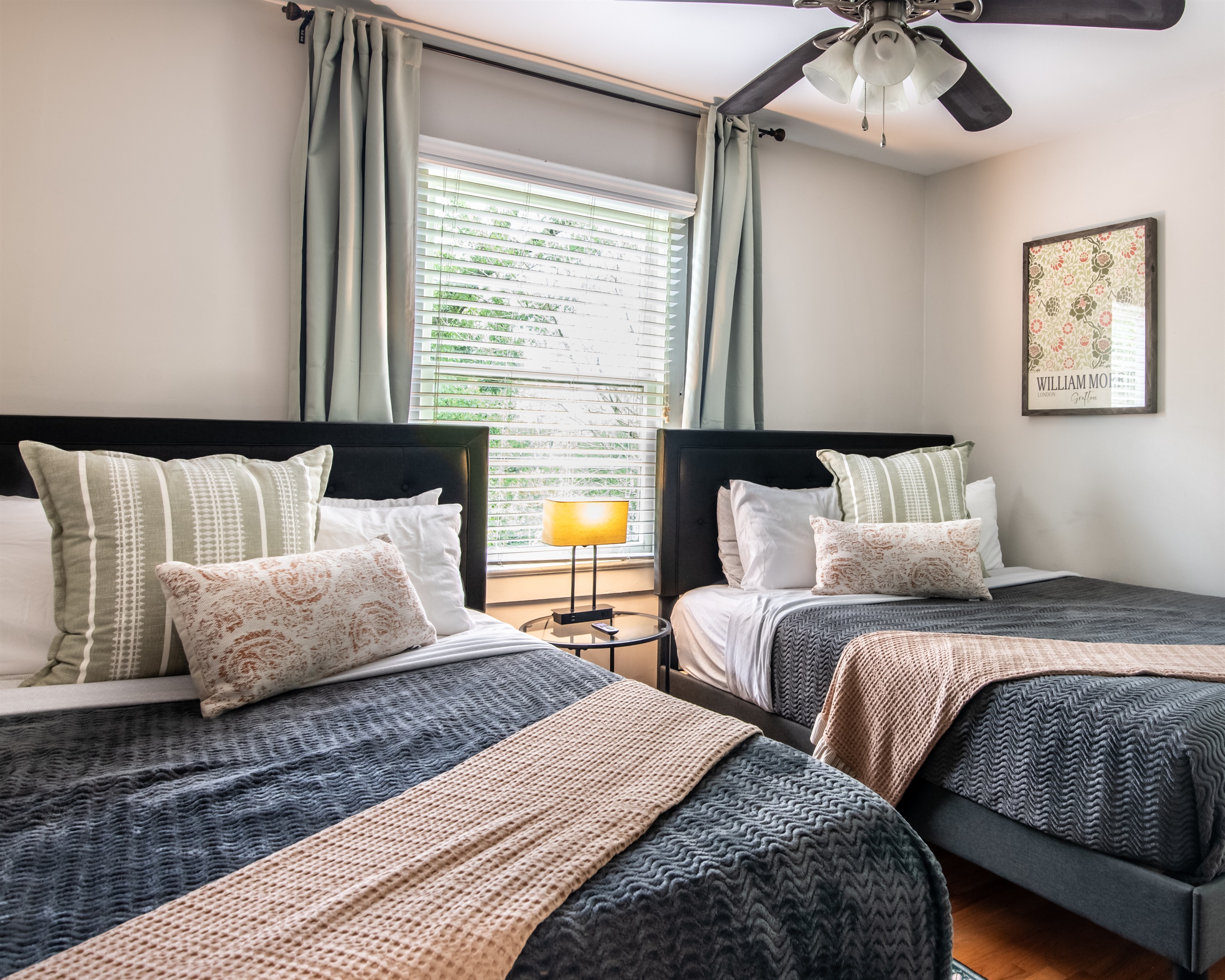 Stylish twin bedroom with natural light, soft bedding, and modern decor — great for kids or friends