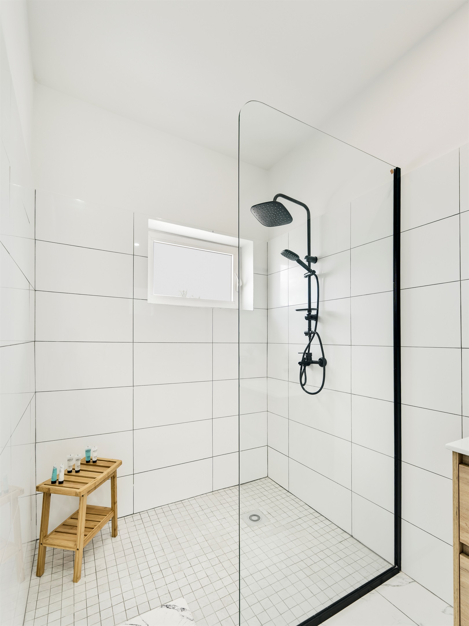 Spacious Walk‑In Shower with Glass Enclosure & Wooden Bench