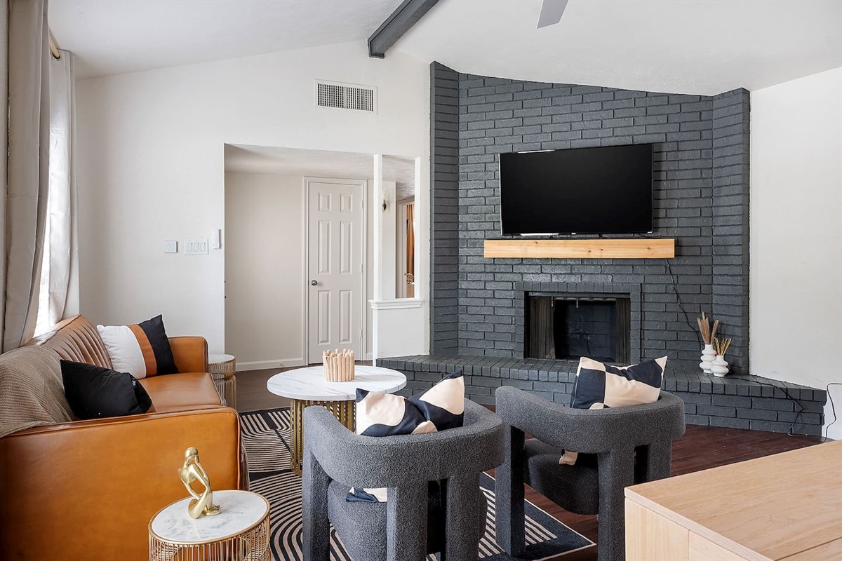 Step into this welcoming living area, highlighted by a sleek fireplace with a mounted TV. Comfortable seating arrangements make it perfect for relaxation.