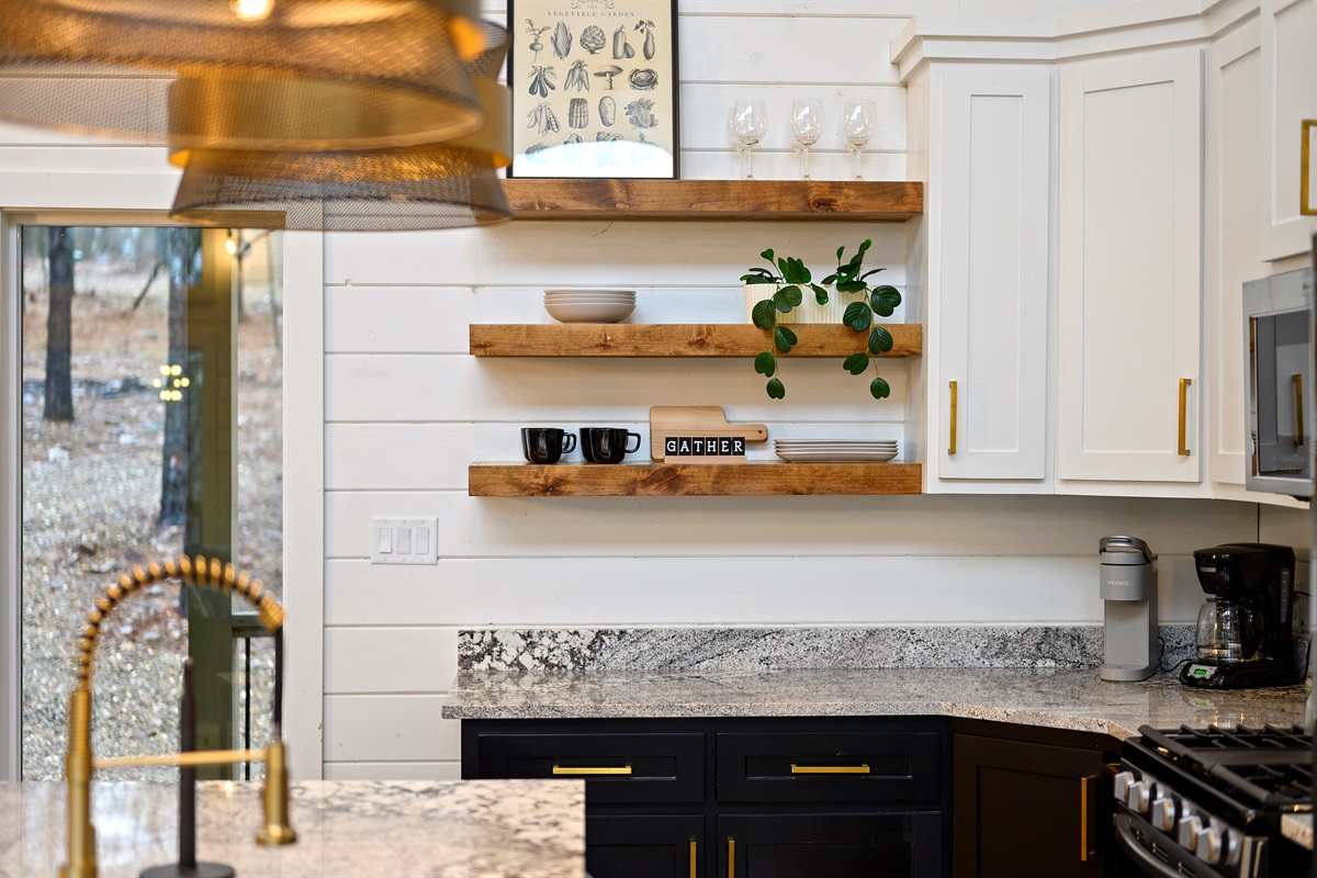 A functional kitchen space with sink, cookware, and dinnerware provided, making it simple to cook, serve, and enjoy meals at the cabin