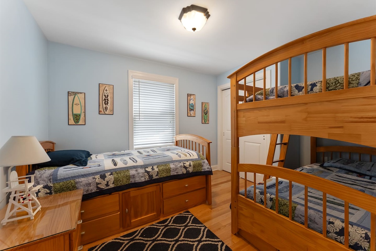 Bedroom features bunk beds and a single bed with a large closet for storage. 