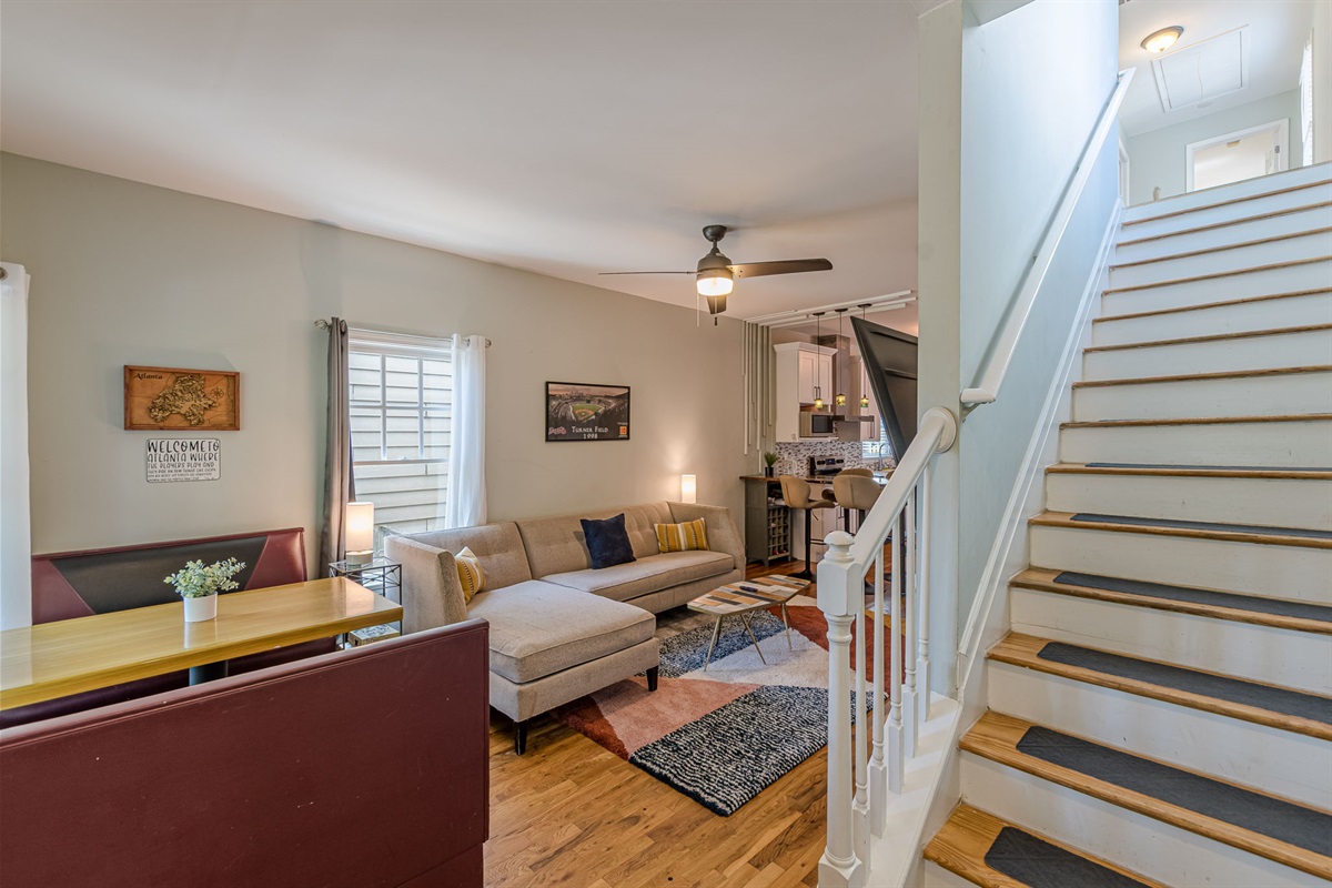 Step inside to an open-concept living space featuring city-inspired décor, including Atlanta landmarks and artwork, with dining, lounge, and kitchen areas all connected.