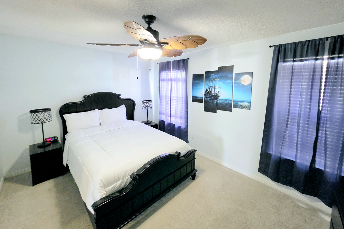 Hideaway side – Primary bedroom: queen bed with pirate-ship art and ensuite bath