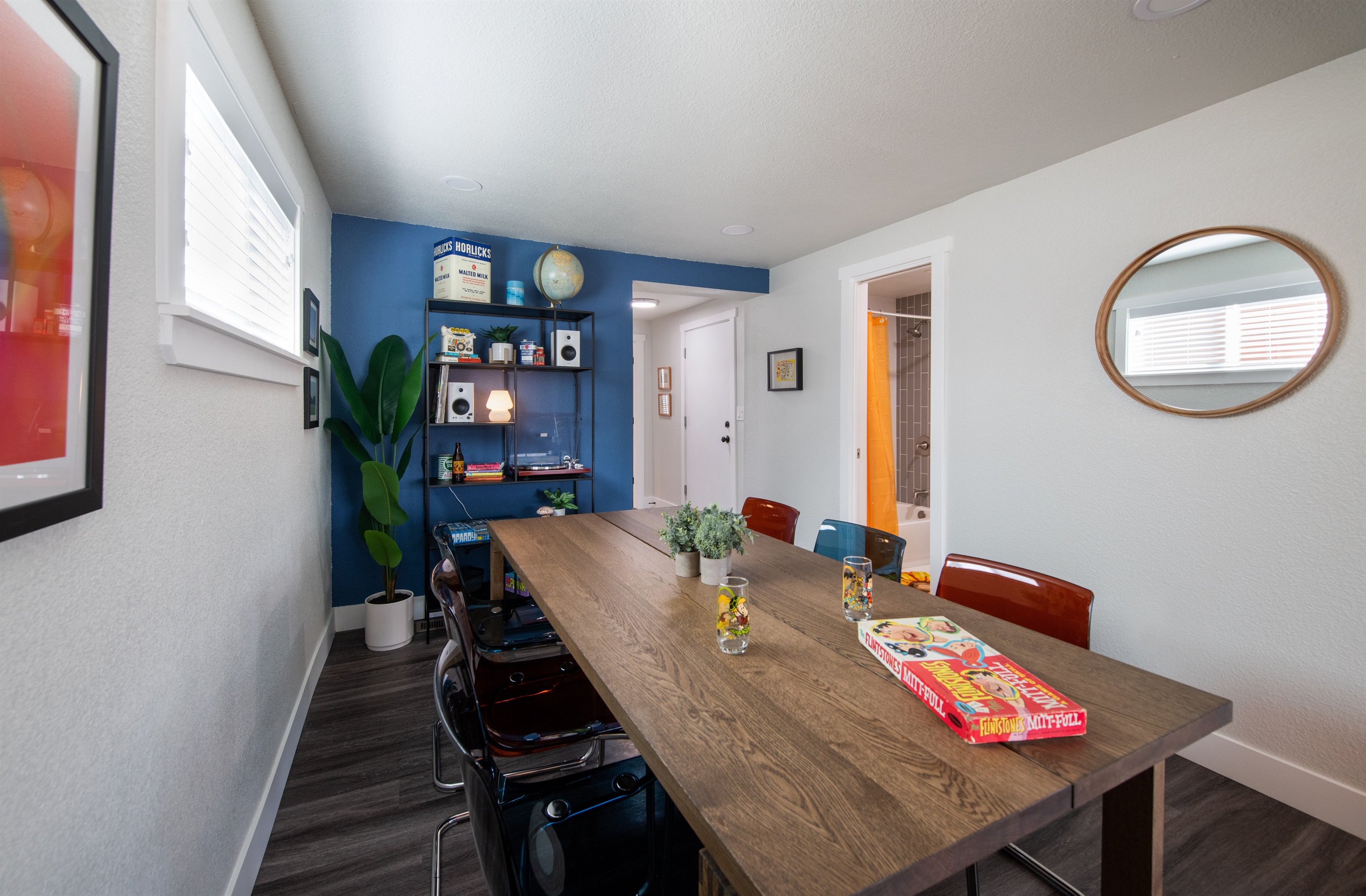 large and spacious dining table and area looking towards back of house and bathroom entrance, and further back towards the laundry room and game room entrance