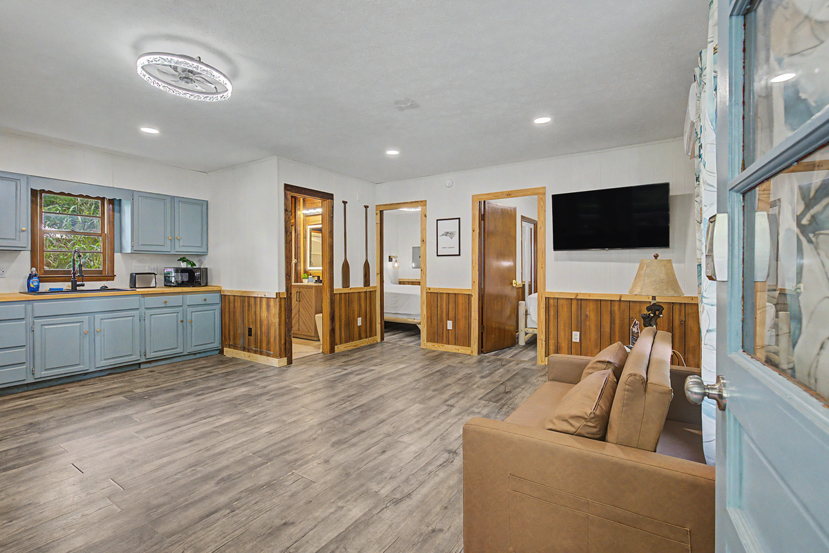 Living Room: Bright space with wooden accents and a sleek TV for entertainment fun!