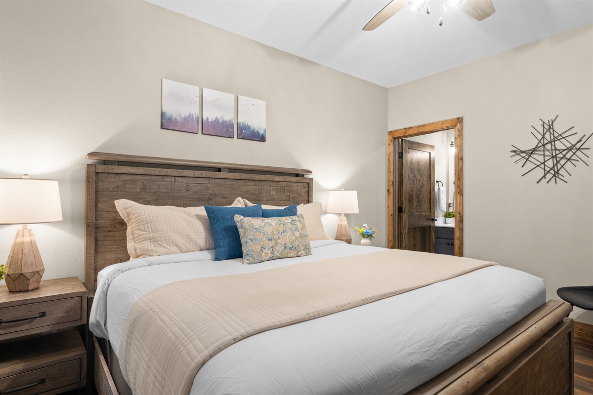 Spacious downstairs king bedroom with luxury linens and ample storage.