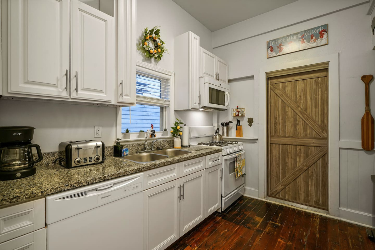Fully equipped farmhouse kitchen with coffee, sugar, creamer, water filter, wine glasses, pots, pans, and everything you need to whip up a meal.