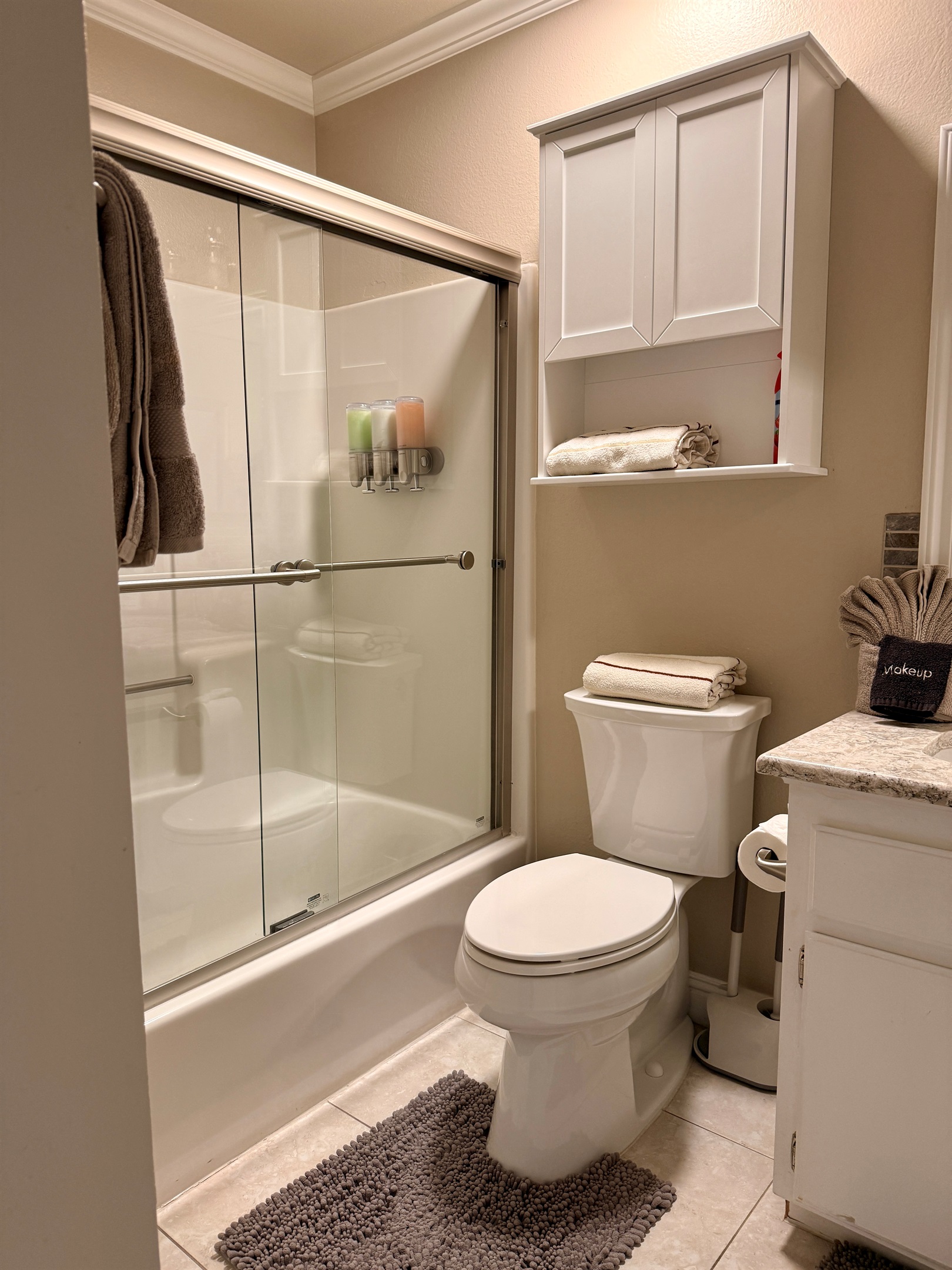 Upstairs hall bath with full shower and bathtub. Stocked with towels, hand towels, wash cloths, labeled makeup removing towels, extra toothbrushes with mini toothpaste, razors, floss, Q-tips, feminine hygiene products, a hair dryer, and a folding stool.