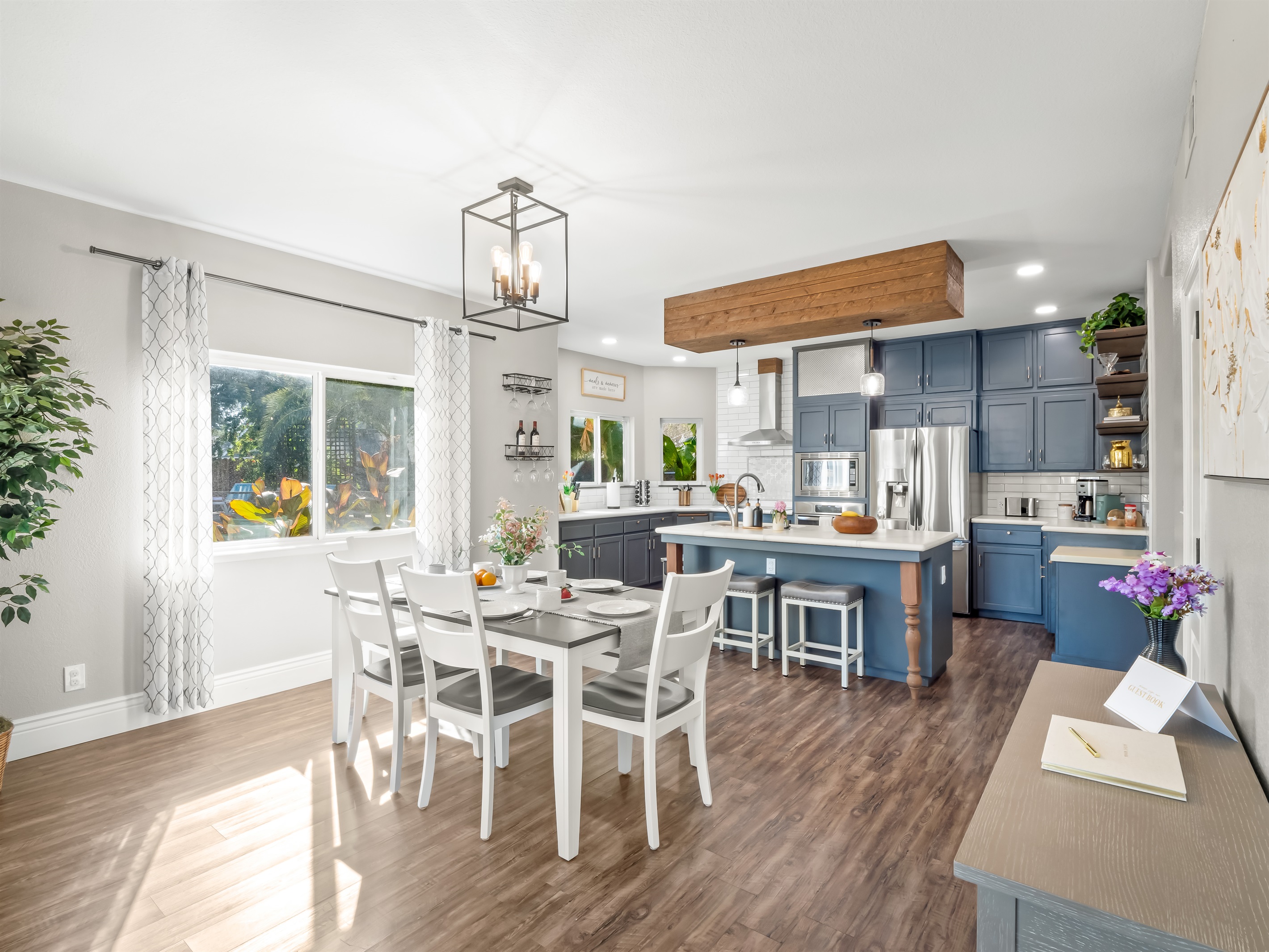 Bright open kitchen and dining area with seating for everyone, a spacious island for casual meals, and a fully equipped kitchen with stainless steel appliances—perfect for cooking, gathering, and making memories together.