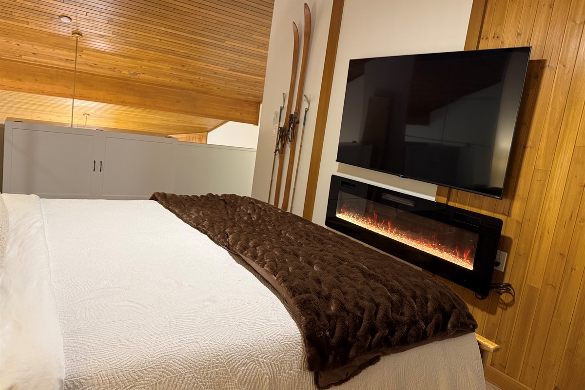 Loft Bedroom Entertainment: Stream your favorite shows on the smart 65" TV enjoying the ambiance of the fireplace. 